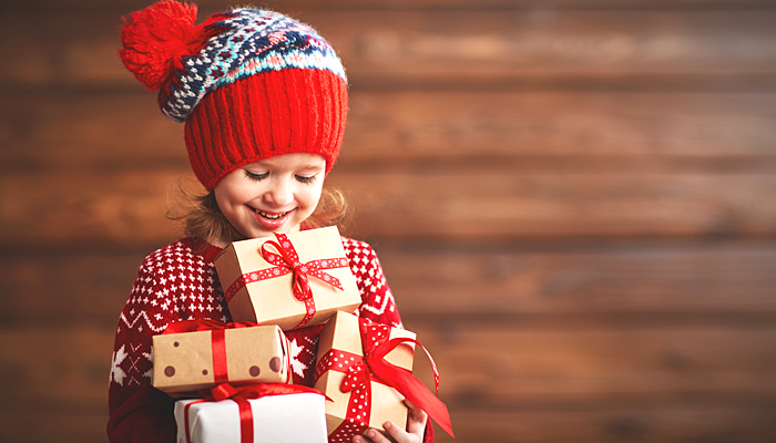 Little Girl in a Winter Beanie Holding Christmas Presents