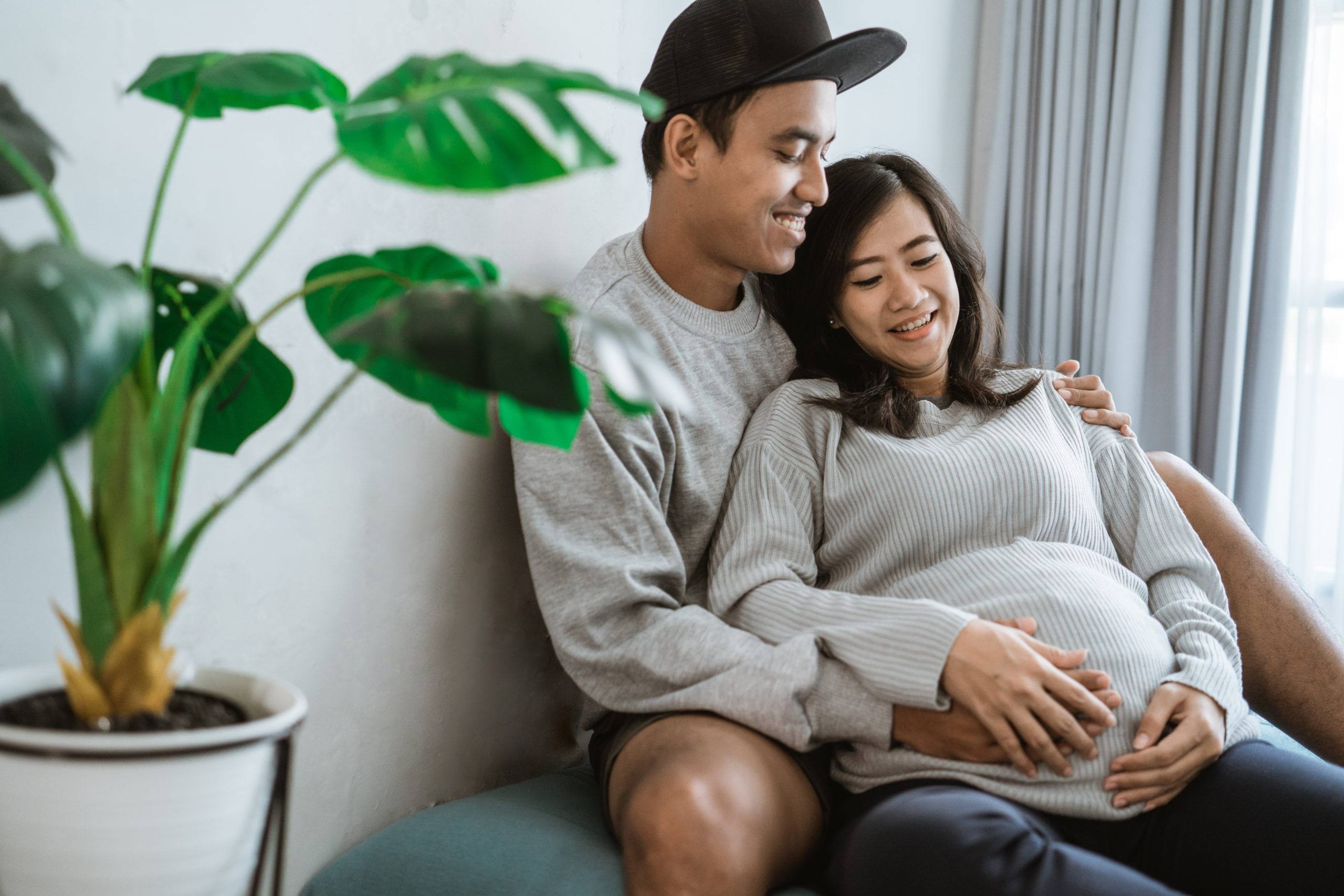 happiness couples holding the wife's pregnant stomach Couple Painting House