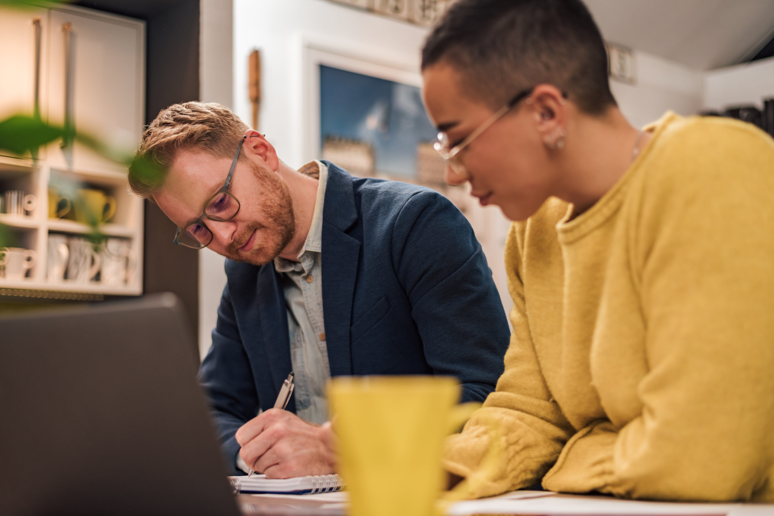 Focused couple of diverse businesspeople doing paperwork togethe Couple Painting House