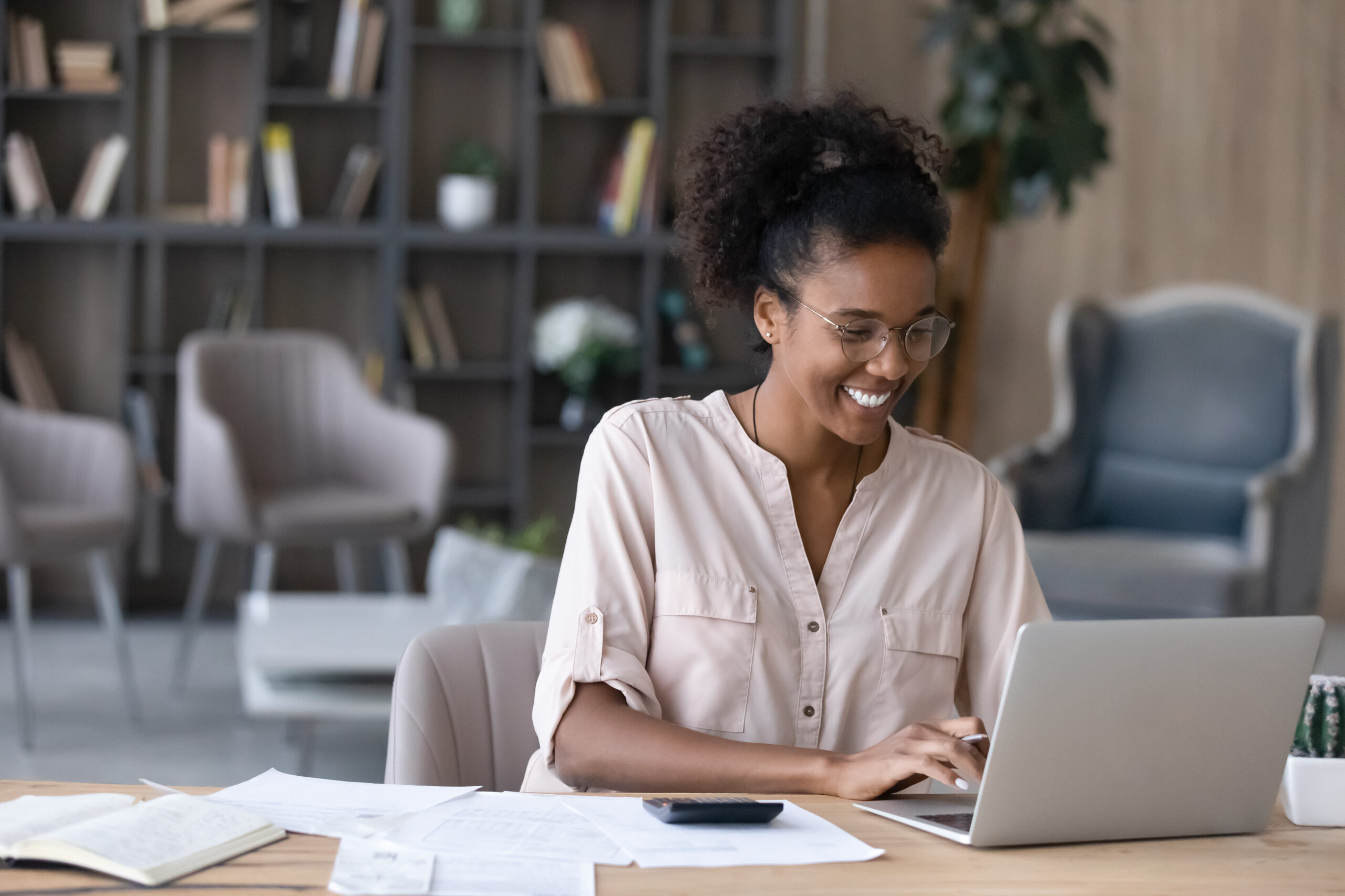 Smiling African American woman manage finances on laptop Couple Painting House
