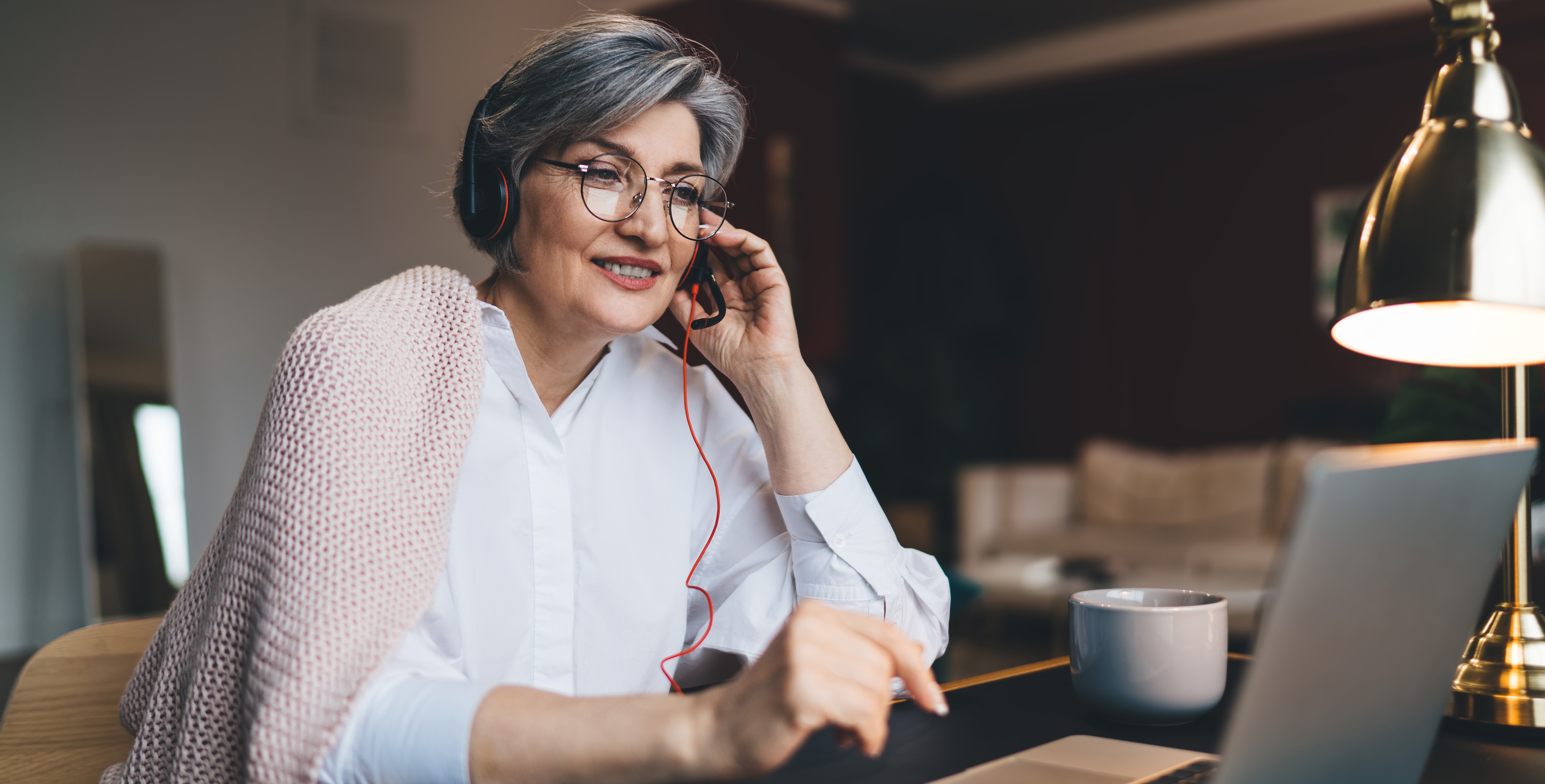 Smiling mature woman attending video call on laptop Couple Painting House